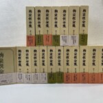 筑摩書房『柳宗悦全集』第1巻から第20巻の函20個。上の段に第十四巻から第二十巻、下の段に第一巻の函の表と第二巻から第十三巻の背。巻名と配本の回を刷った帯が付く。第21巻と第22巻は写っていない
