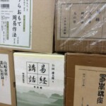 公田連太郎『易経講話』全五巻や柄澤照覺『易學講座』、山崎泰廣の講伝など、函入りの易経の全集が積まれた様子