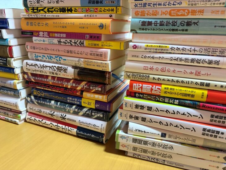八尾市で出張買取した多ジャンルの蔵書。スピリチュアルや色彩・手芸、歴史散歩などの本が積み重ねられている様子