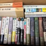 市中区で出張買取した多ジャンルの教養蔵書。ウンベルト・エーコ『薔薇の名前』やハラリ『ホモ・デウス』、バッハ関連の研究書などが箱に詰まった様子