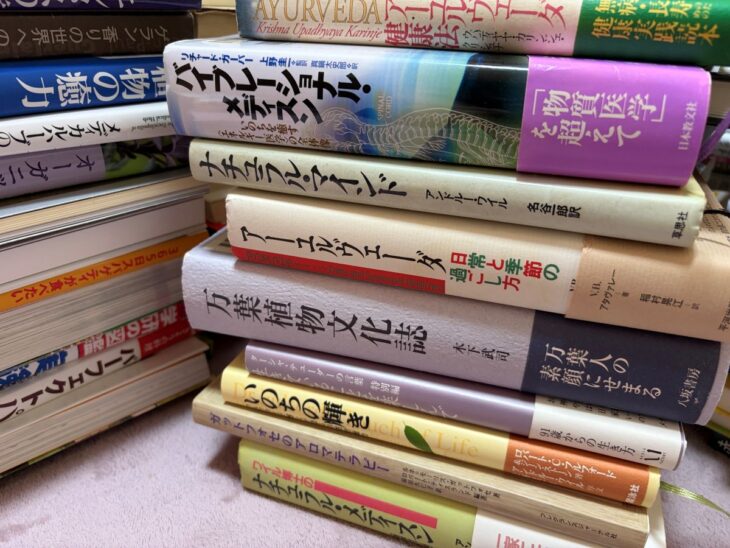 神戸市北区の出張買取でアーユルヴェーダ・和ハーブ・薬草文化の本を約300冊お譲りいただきました。ジェニー・ハーディング『ハーブ図鑑』や万葉植物文化誌などが積まれた様子