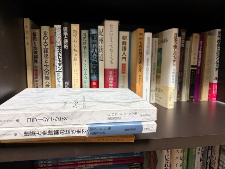 建築論と都市論の単行本が並ぶ棚。手前には鹿島出版会の函入り大型本が2冊、横に積まれた様子