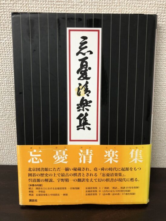 忘憂清楽集の黒いカバーに題字が入り、黄色い帯に世界最古の棋書と呉清源の解説であることが書かれている
