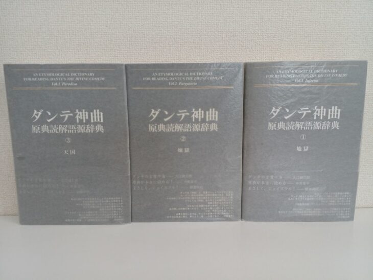 ダンテ神曲原典読解語源辞典3巻が並ぶ。銀色のカバーに縦書きの書名