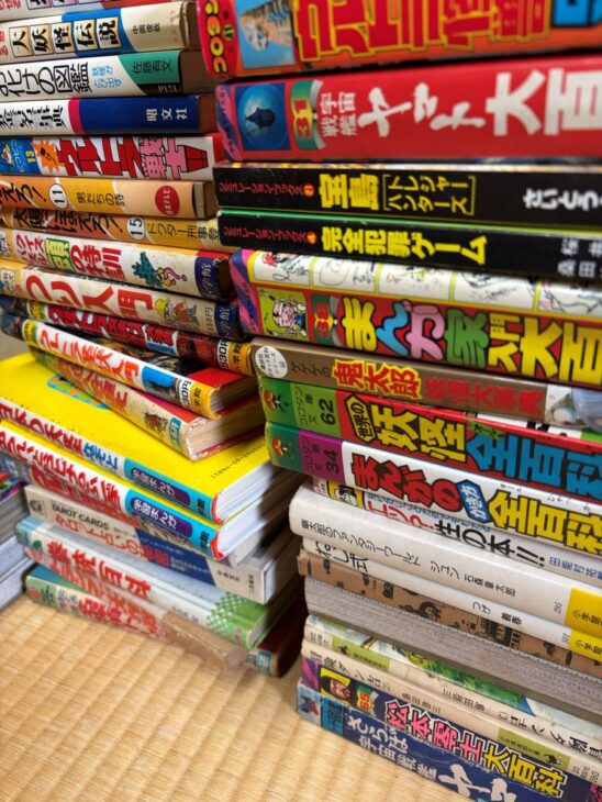 小学館コロタン文庫の『世界の妖怪全百科』や中岡俊哉『大妖怪伝説』など昭和の児童向け大百科が二列に積まれた畳の上