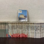 保育社カラーブックスの鉄道の巻56冊が背を見せて横一列に並び、上に0系新幹線の表紙の日本の鉄道が立っている