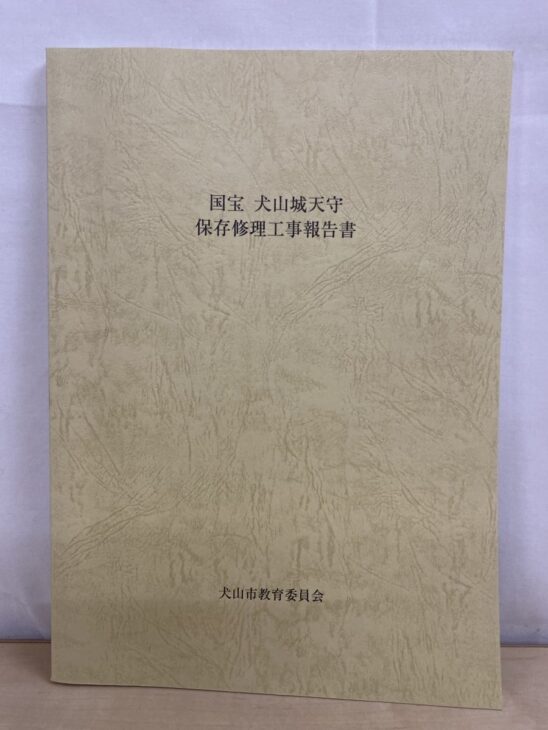 クリーム色の表紙に国宝 犬山城天守 保存修理工事報告書と刷られ、下に犬山市教育委員会と入っている