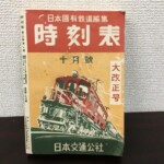 時刻表 大改正号の表紙。赤と黄と緑の三色刷りで、パンタグラフのある車両を描いた図案