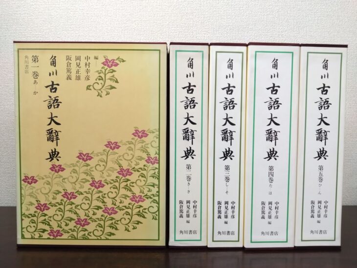 角川古語大辞典の第一巻の函に桔梗の花柄が刷られ、右に第二巻から第五巻までの白い函が並んでいる