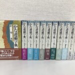 代替テキスト かな連綿字典と背に入った函が11冊並び、系統名と配本の帯が付いたところ