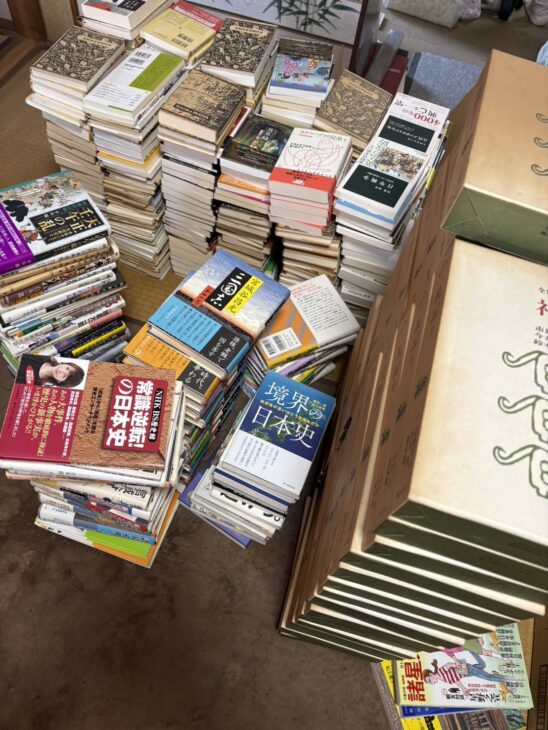 畳の部屋に平積みされた歴史書と文庫。宮城谷昌光『三国志』や『境界の日本史』が見える