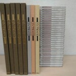 原典による近代唱歌集成の茶色い函5冊と演奏用楽譜3冊、右にCD30枚が背を見せて並ぶ