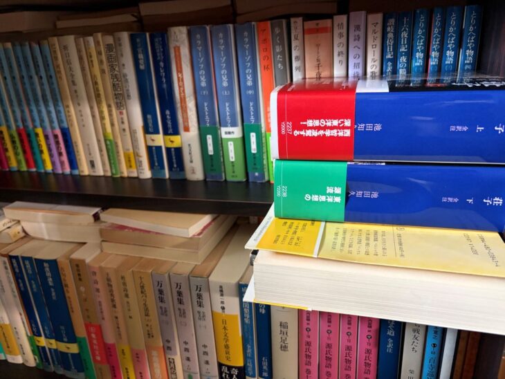 ドストエフスキー『カラマーゾフの兄弟』や中西進『万葉集』など文庫と学術文庫が段ごとに詰まった書棚