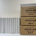 ニューグローヴ世界音楽大事典の黒い函2冊と灰色の本体が並び、右に13巻から20巻が入った講談社の輸送用ダンボール3箱が積まれている