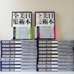 帯の付いた函入り2冊と、戦争と美術など巻名の入った背が並ぶ日本美術全集の20冊
