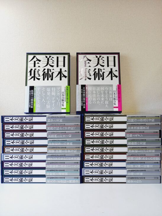 帯の付いた函入り2冊と、戦争と美術など巻名の入った背が並ぶ日本美術全集の20冊