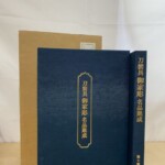 紺の布張りに金の箔押しで刀装具 御家彫 名品聚成と入った本と、後ろに厚紙の輸送函が立てて置かれている