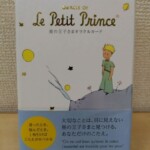 星の王子さまオラクルカードの白い箱。Le Petit Princeの金の箔押しと、星の上に立つ王子の絵が入り、下に水色の帯が掛かっている