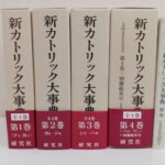 新カトリック大事典6冊が並ぶ。第1巻から第4巻と別巻の背表紙