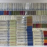 新日本古典文学大系の色分けされた函が三段に並び、謡曲百番や太閤記、萬葉集などの巻名が背に入っている