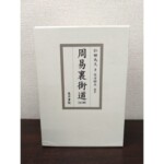 周易裏街道の白い函が立てて置かれ、灰色の罫で囲んだ枠に書名と著者名が縦書きで入る