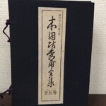 紺の布張りの帙に紫の組紐が掛かり、縦長の題簽に歴代名人打碁大系 本因坊秀甫全集 全五巻と入っている