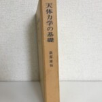 天体力学の基礎の函の背に萩原雄祐の著者名と生産技術センターの版元名が入り、生成りの函に経年の焼けが出ている