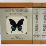 図鑑 東南アジア島嶼の蝶の第1巻アゲハチョウ編の函に黒い翅に青い帯の蝶が刷られ、右に第2巻と第3巻が並んでいる