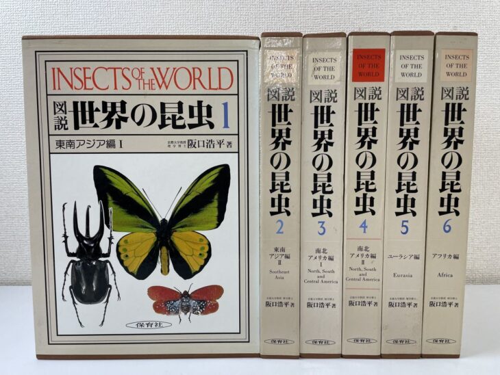 図説 世界の昆虫の第1巻の函に蝶とカブトムシが刷られ、右に東南アジア編から アフリカ編までの6巻が並んでいる