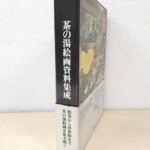 平凡社『茶の湯絵画資料集成』の函。黒い背に白い字の書名、表に金色の雲と建物の中の人物を描いた絵、下の3分の1ほどに「絵巻から浮世絵まで」と刷られた白っぽい帯
