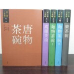 赤茶色の第一巻『唐物茶碗』を正面に向け、薄紫、緑、水色、灰色の背の第二巻から第五巻を並べた淡交社『茶の湯の茶碗』
