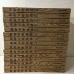 木目模様の背に朝鮮古蹟圖譜の書名と一から十五の巻数、名著出版刊の文字が入った復刻版15冊を積み重ねたもの