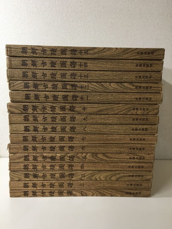 木目模様の背に朝鮮古蹟圖譜の書名と一から十五の巻数、名著出版刊の文字が入った復刻版15冊を積み重ねたもの