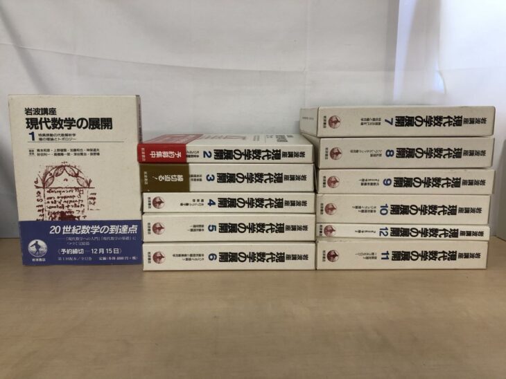 白地に青い文字の函が12個並んだ『岩波講座 現代数学の展開』全12巻で、第1巻には「20世紀数学の到達点」の帯が付く