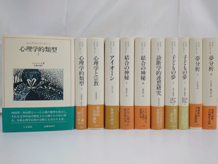人文書院『ユング・コレクション』11冊。左端の第1巻『心理学的類型Ⅰ』は表と緑の帯を見せ、右の10冊は背に2から9、13、14の巻数と書名、下にオレンジ色などの帯