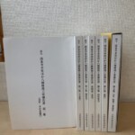 国宝 清水寺本堂ほか八棟修理工事報告書の第二集から第七集を立てて並べ、第一集の表紙(馬駐・本坊北総門)を手前に置いた京都府教育委員会の7冊