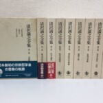 帯の掛かった第一巻の函の表と、第二巻から第九巻の背が並ぶ岩波書店『清沢満之全集』の函9つ