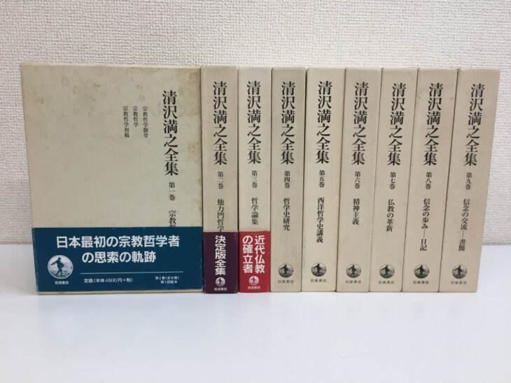 帯の掛かった第一巻の函の表と、第二巻から第九巻の背が並ぶ岩波書店『清沢満之全集』の函9つ