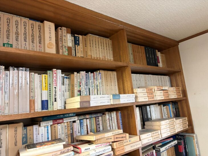 最上段に高村光太郎選集と函入りの小林秀雄全集、二段目に吉田秀和『世界のピアニスト』と白い函の遠山一行著作集が並ぶ木の書棚