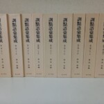 汲古書院『訓點語彙集成』のクリーム色の函9つ。背に旧字の大きな書名と、第一巻 あ〜いから第八巻 も〜ん、別巻 漢字索引の巻数、築島裕 編と汲古書院の文字が並ぶ