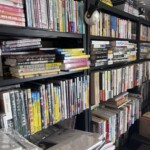 黒い書棚の上段に成瀬巳喜男のDVDと三島敏夫大全集のCD、右の棚に映画の本と文庫が並ぶ壁一面