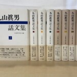 『丸山眞男話文集』の第1巻を表紙向きに立て、第2巻から第4巻と続1から続4の背を帯付きで並べた8冊