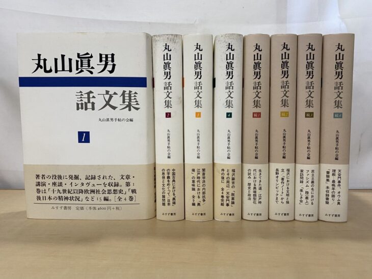 『丸山眞男話文集』の第1巻を表紙向きに立て、第2巻から第4巻と続1から続4の背を帯付きで並べた8冊
