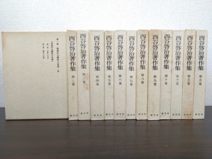 西谷啓治著作集の第一巻の白い函を手前に置き、第二巻から第十三巻の函を並べた創文社の全集。第一巻の函に根源的主體性の哲學の題簽