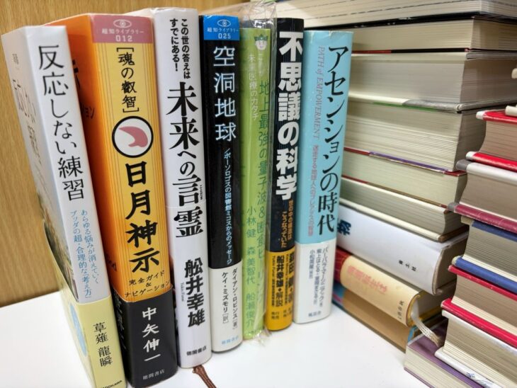 中矢伸一『日月神示 完全ガイド&ナビゲーション』、舩井幸雄『未来への言霊』、『アセンションの時代』が机に並んだ精神世界の本