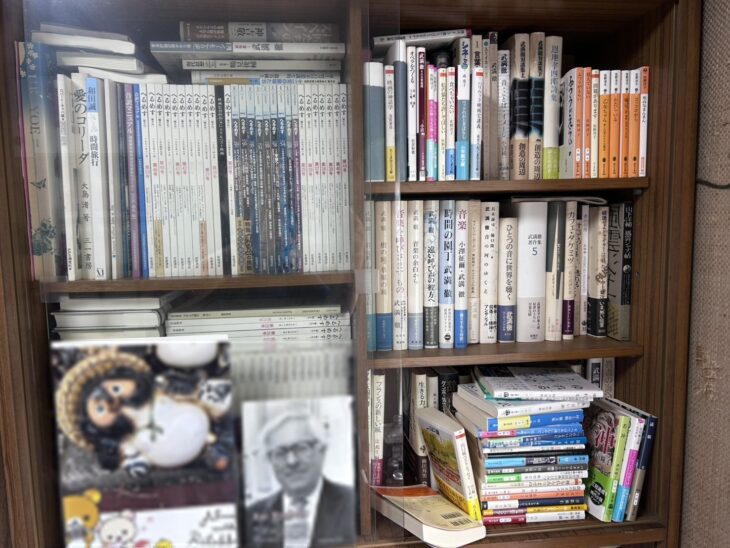 ガラス戸の本棚。左に岩波書店の雑誌『へるめす』が数十冊、右に武満徹の本と武満徹対談集の段