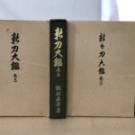 茶色い函に筆文字で『新刀大鑑』『新々刀大鑑』と入り、緑と紺の背に金文字で飯村嘉章著とある大型本4冊