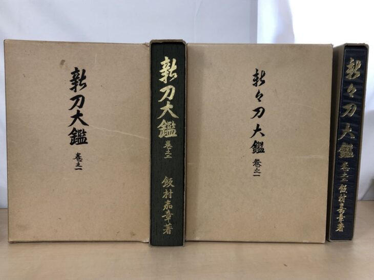 茶色い函に筆文字で『新刀大鑑』『新々刀大鑑』と入り、緑と紺の背に金文字で飯村嘉章著とある大型本4冊