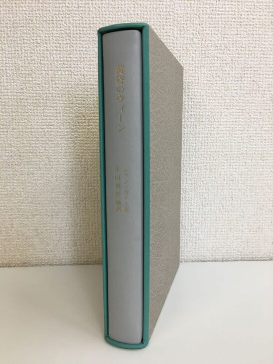 奢灞都館の特装本『黄昏のウィーン』を函に入れて立てたところ。灰色の函の口は緑で縁取られ、明るい灰色の背に書名と「ジャン・カスー著 生田耕作翻訳」の金色の文字