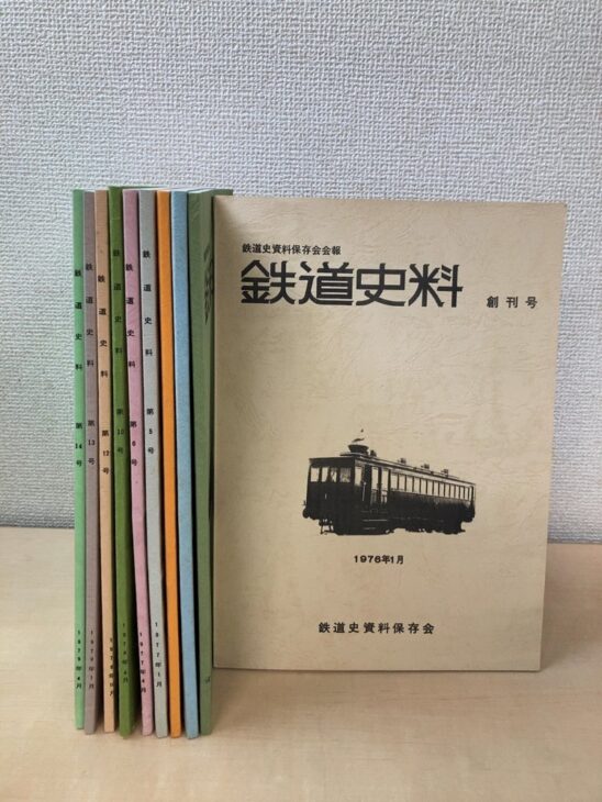 鉄道史資料保存会会報『鉄道史料』の創刊号(1976年1月・古い電車の写真)を手前に立て、緑や桃色や橙の表紙の第5号から第14号を並べた10冊